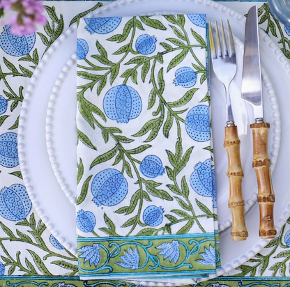 Patterned napkin on a white plate with cutlery and bamboo handles
