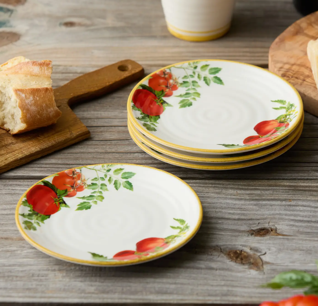 Set of ceramic plates with tomato design on a wooden table