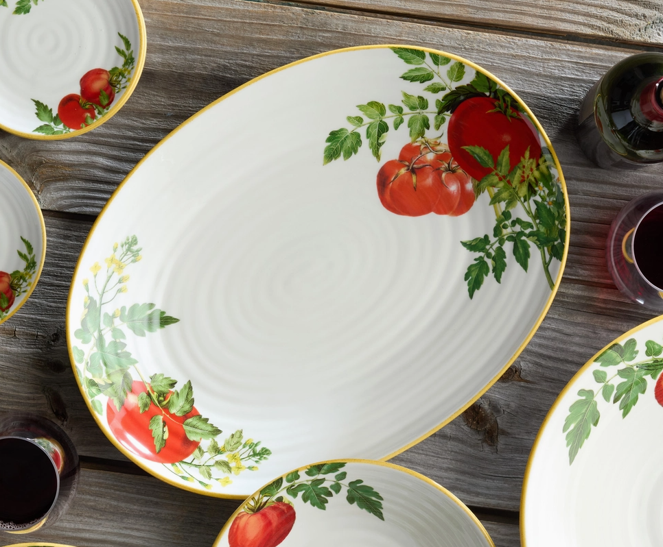 Set of ceramic plates with tomato design on a wooden surface