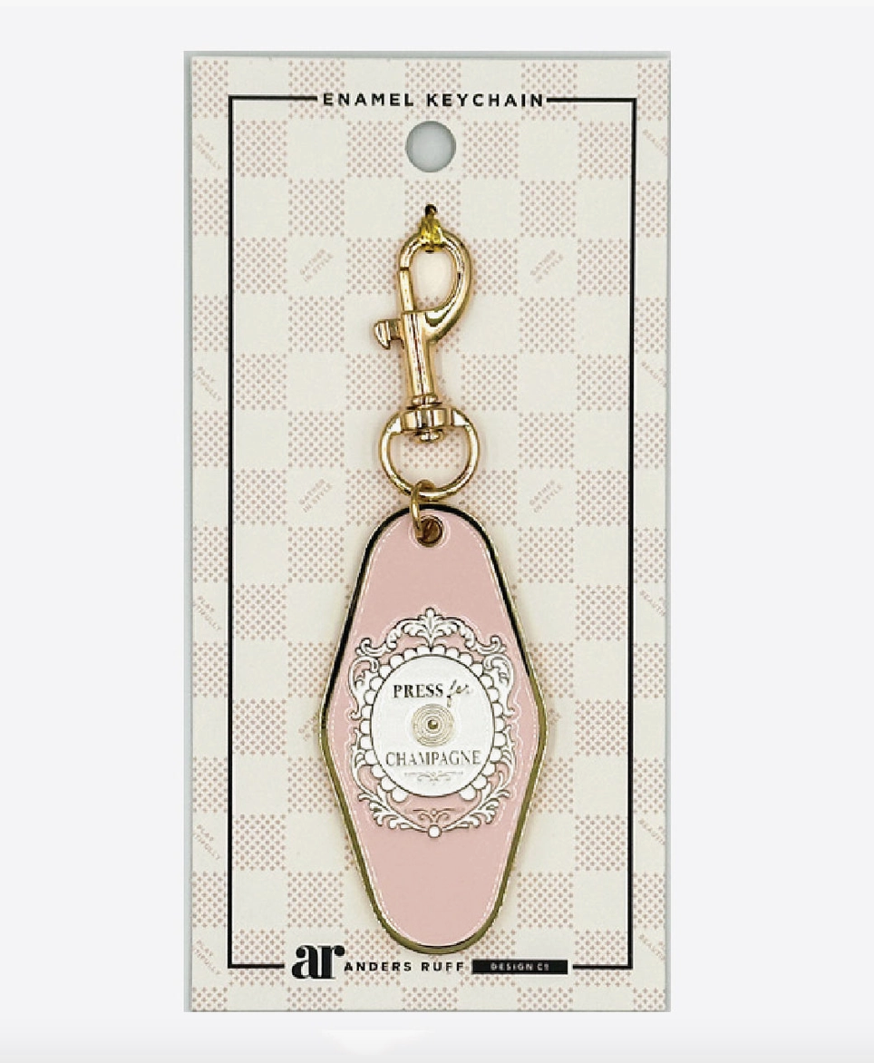 Press for Champagne Mahjong enamel keychain charm by Anders Ruff in blush pink with ornate medallion and gold-tone lobster clasp.