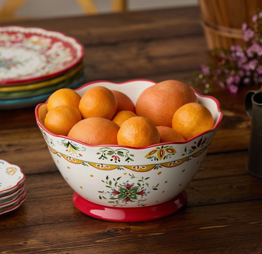 Decorative bowl filled with oranges on a wooden table