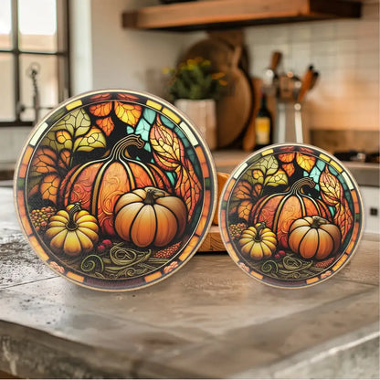 Two decorative plates with autumn-themed designs featuring pumpkins on a kitchen counter.