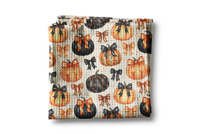 Baby blanket with pumpkin and bow pattern on a white background
