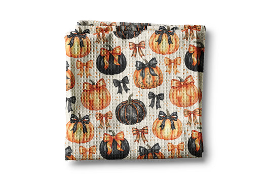 Baby blanket with pumpkin and bow pattern on a white background