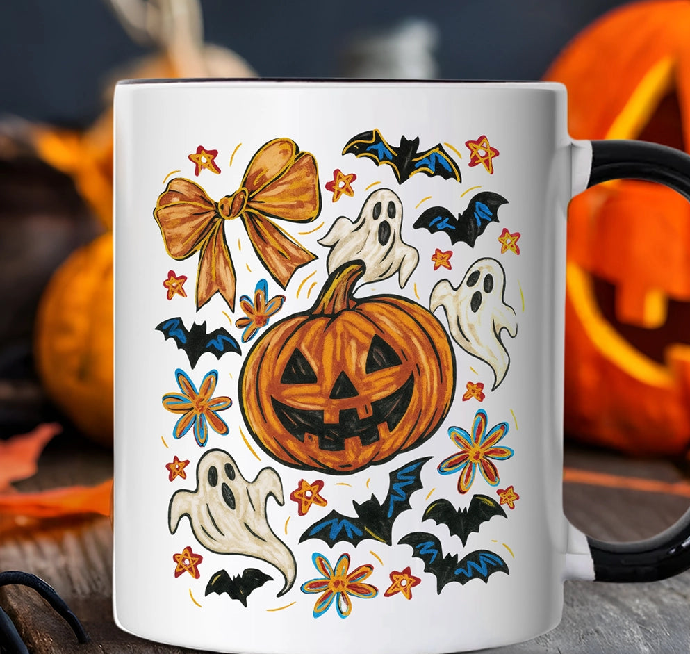 White mug with Halloween-themed design featuring pumpkins, ghosts, and bats on a wooden surface with pumpkins in the background.