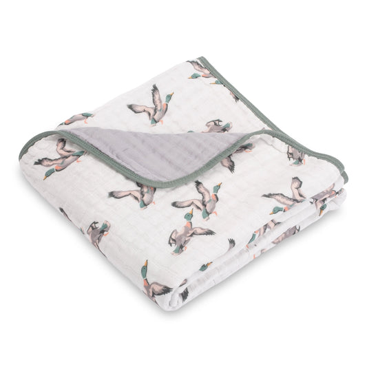 Folded baby blanket with bird pattern on a white background