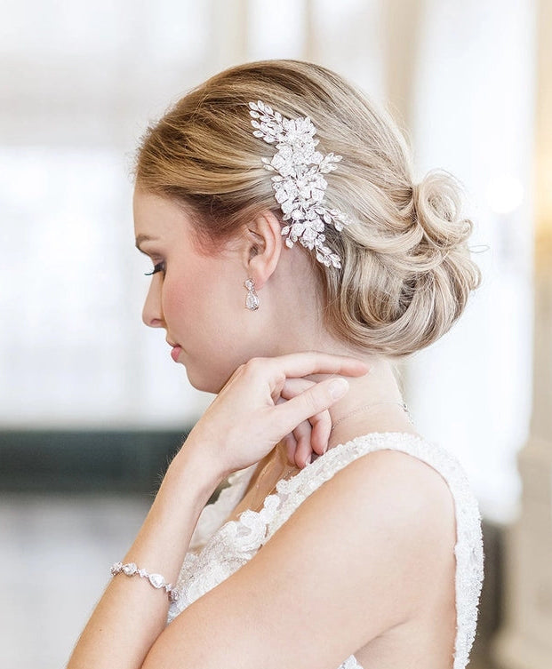 Bride in a white dress with a decorative headpiece, standing indoors.
