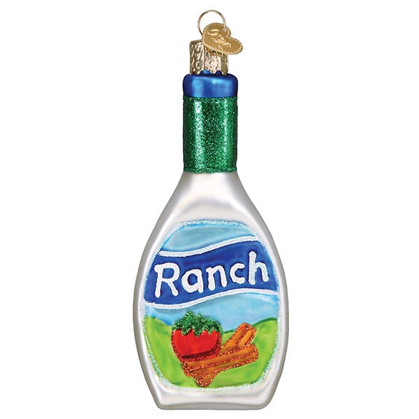 A Christmas ornament shaped like a bottle of Ranch dressing, with a silver body, green glitter neck, blue cap, and a printed Ranch label showing a red tomato and cinnamon sticks.