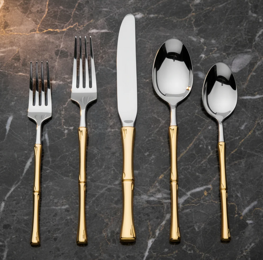 20-piece stainless steel flatware set with elegant gold rattan-inspired handles displayed on dark marble.