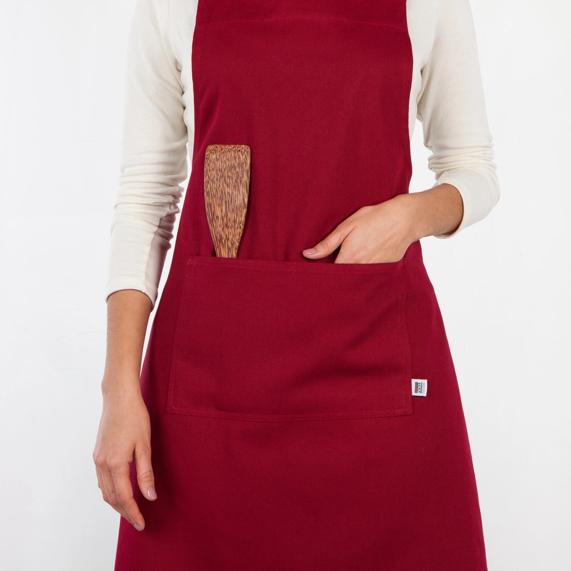 Red apron with a wooden paddle on a white background
