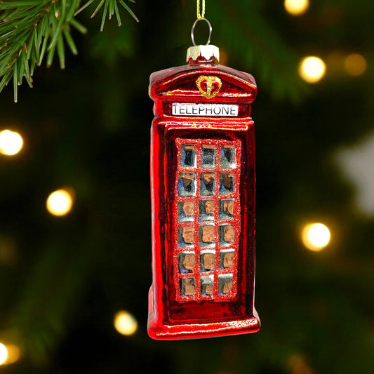 Red telephone booth ornament on a Christmas tree with blurred lights in the background
