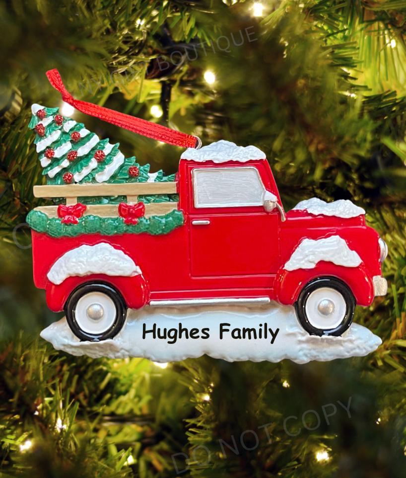 Red truck Christmas ornament with a tree on a green tree background