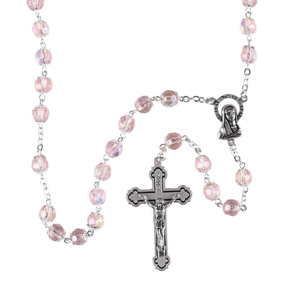 Pink rosary with silver crucifix and Our Lady of Lourdes medal on a white background