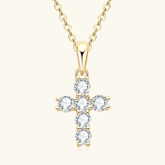 Gold cross-shaped pendant with clear stones on a white background