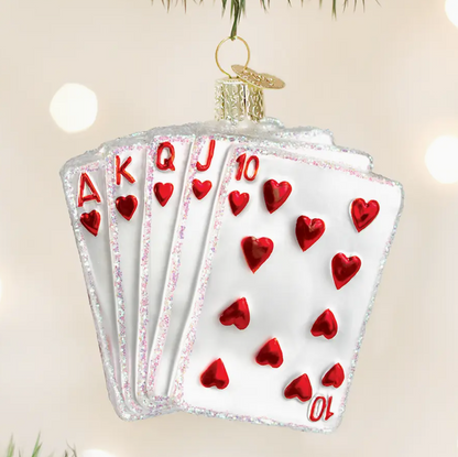 Decorative ornament shaped like a fan of playing cards with red hearts on a beige background.