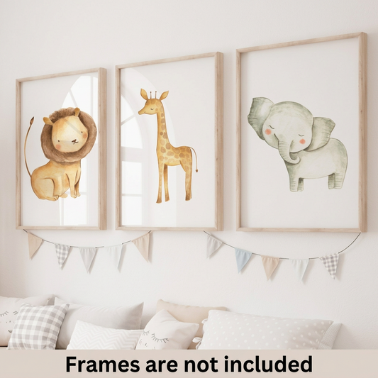 Set of three watercolor safari nursery wall art prints featuring a lion, giraffe and elephant displayed in natural wood frames above a nursery bed.