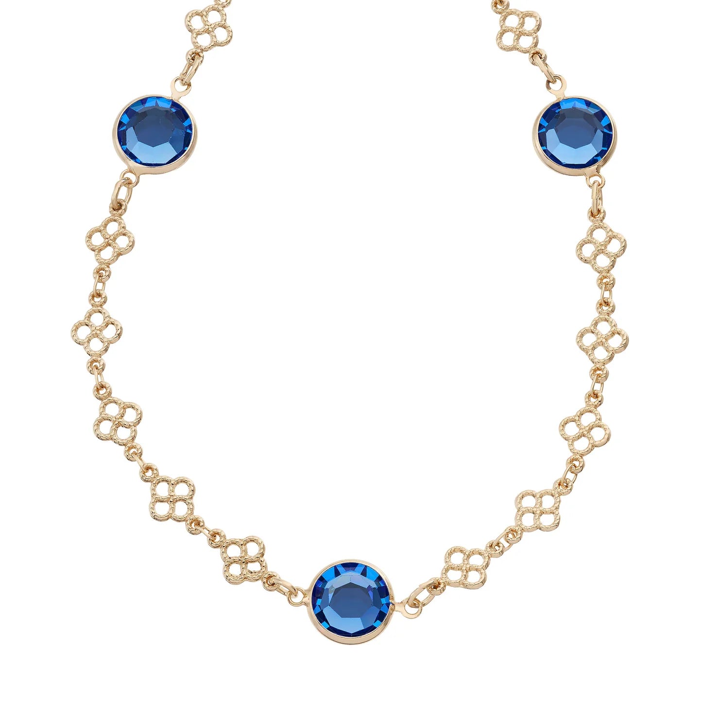 A gold-tone chain necklace featuring three round-cut blue faceted gemstones set in gold bezels, displayed on a clean white background.