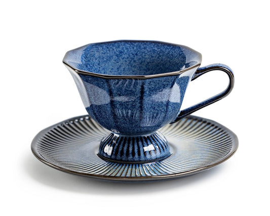 Blue ceramic teacup and saucer on a white background