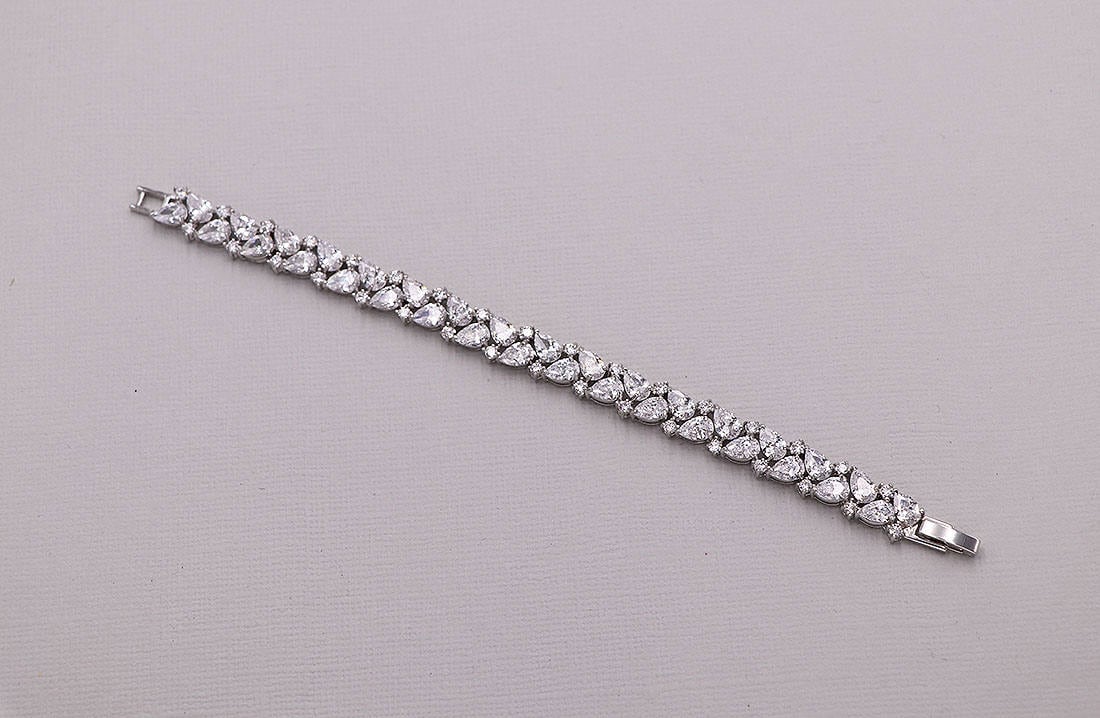 Silver bracelet with clear stones on a gray background