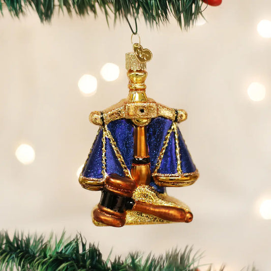 Decorative ornament resembling a judge's gavel and scale on a Christmas tree.