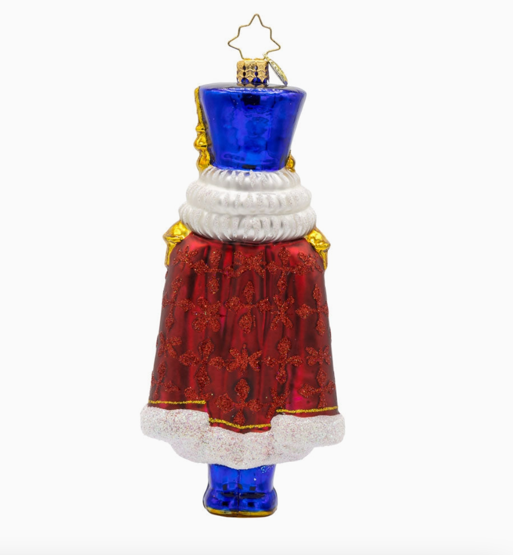 Back of Christopher Radko Long Coat Nutcracker glass ornament with glittered red cape and royal blue hat