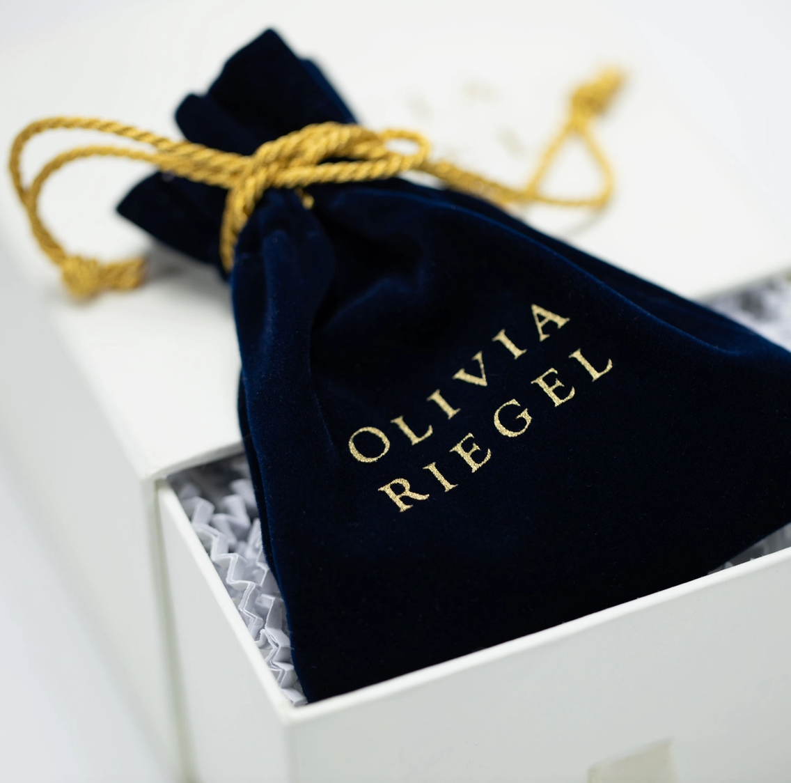 Olivia Riegel navy velvet jewelry storage pouch with gold logo