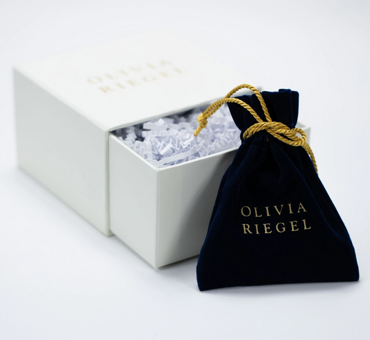 Olivia Riegel jewelry gift packaging with navy velvet pouch
