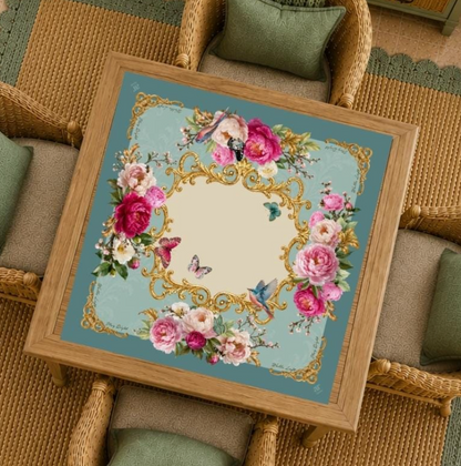 Mahj in Bloom floral Mahjong mat by Anders Ruff displayed on a wood game table surrounded by wicker chairs in a garden-inspired setting.