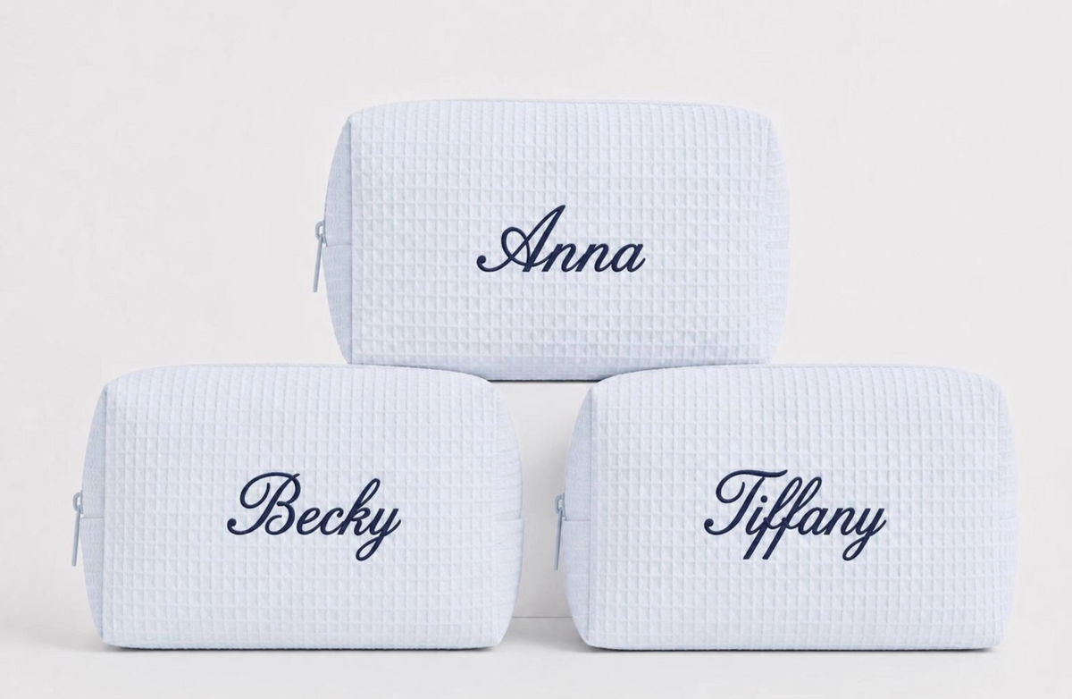 Personalized light blue waffle makeup bags with custom names embroidered in navy thread