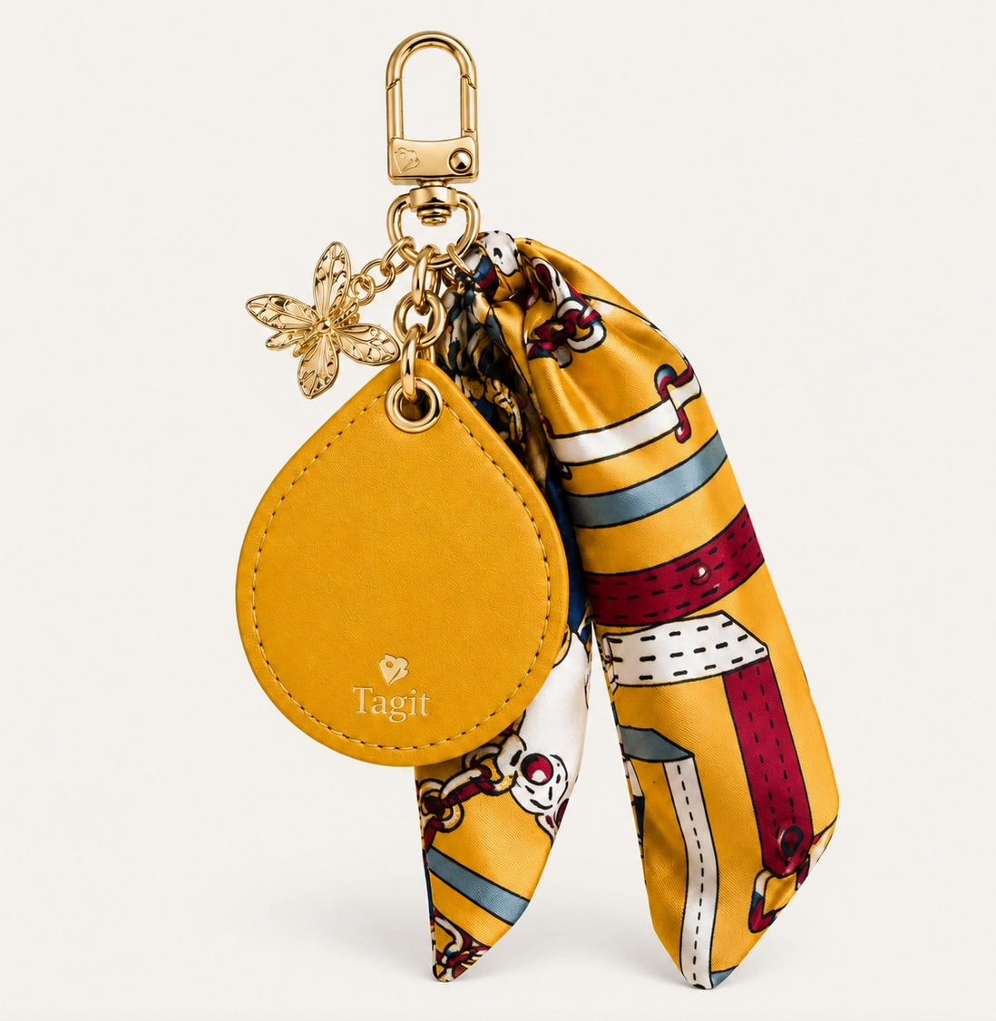 Mustard yellow vegan leather AirTag bag charm with colorful scarf, gold-plated bee-inspired charms and clip