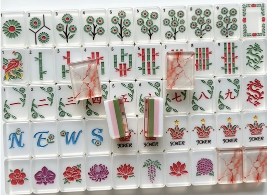 Southern Garden American Mahjong tiles with white botanical faces, pink green striped edges and translucent blush marbled backs