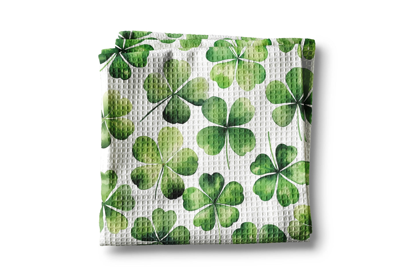 Waffle-textured kitchen towel with green four-leaf clover pattern on a white background