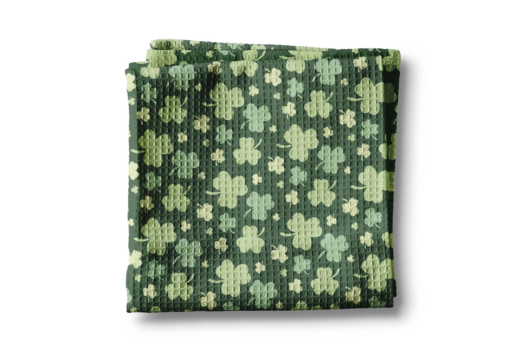Folded green fabric with shamrock pattern on a white background