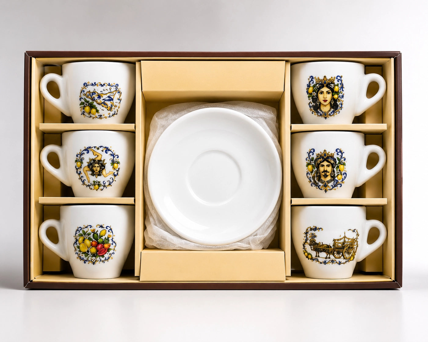 A boxed ceramic tea or coffee cup and saucer set displayed in an open presentation box. The set includes six white cups with colorful illustrated floral and portrait designs, six matching saucers, and a stack of clear plastic-wrapped plates or napkins in the center, all set against a light gray background.