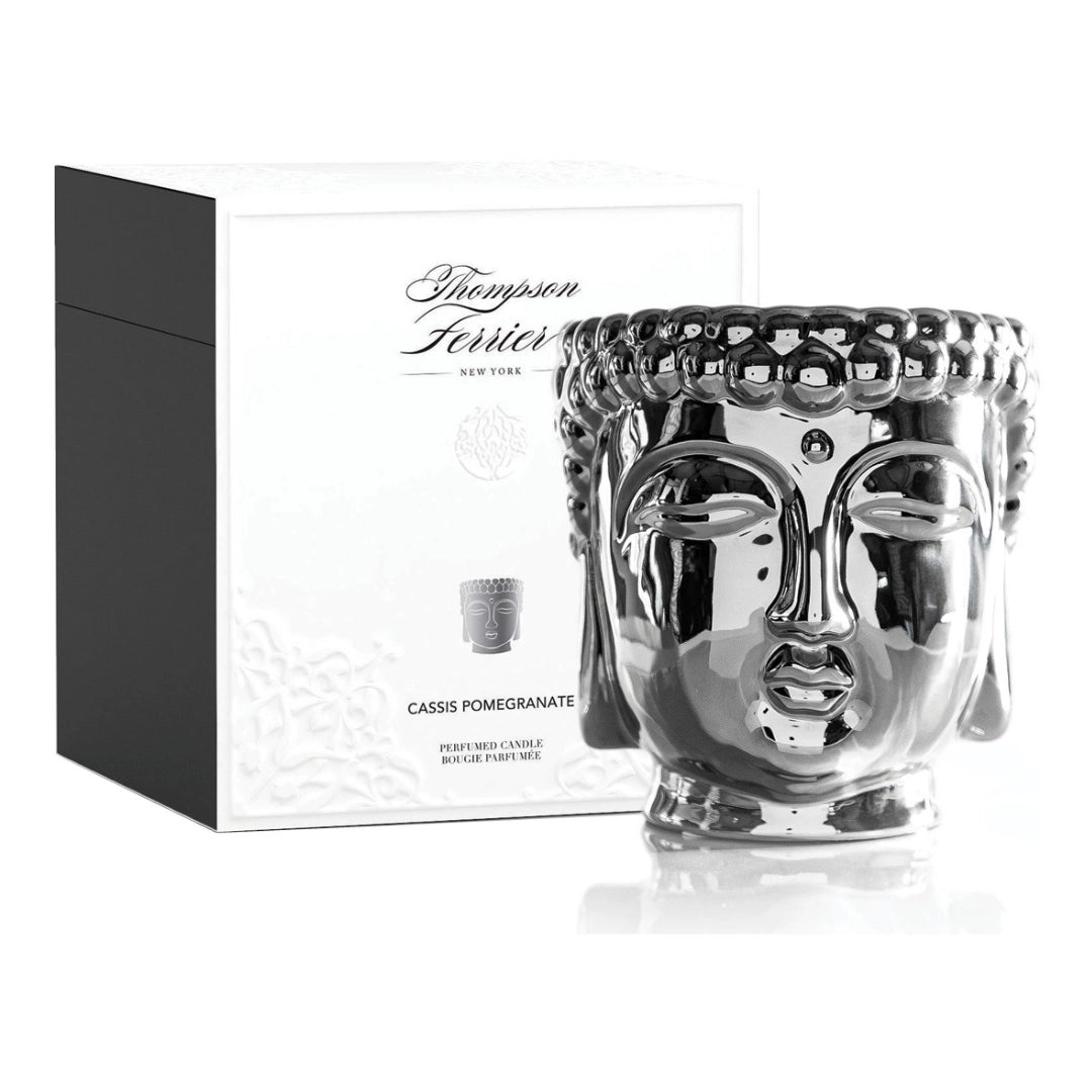 Silver Buddha face candle with packaging on a white background