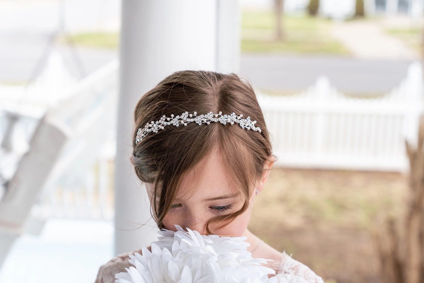 Young girl wearing a decorative headband with a blurred outdoor background