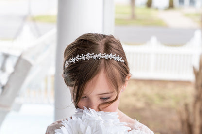 Young girl wearing a decorative headband with a blurred outdoor background