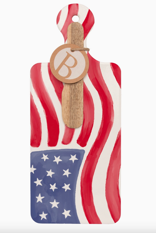 American flag-themed cutting board with a wooden paddle on a white background