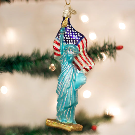 Statue of Liberty ornament with American flag against a Christmas tree background