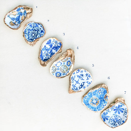 Decorative oyster shells with blue and white patterns on a white background