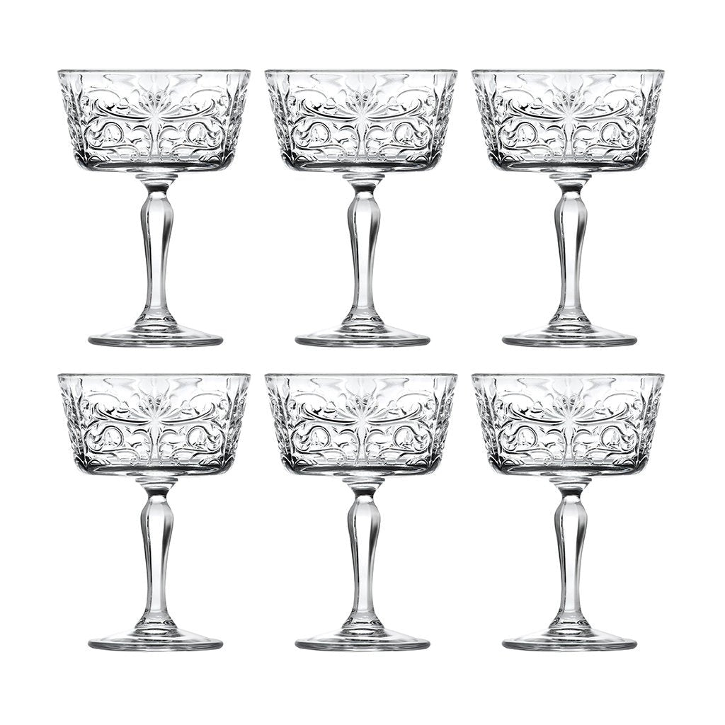 Set of six crystal glasses with intricate designs on a white background