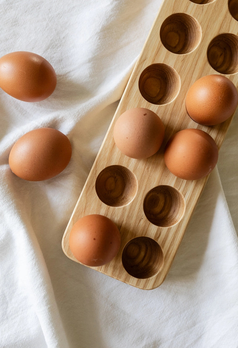 Brown eggs on a wooden egg holder on a white cloth background