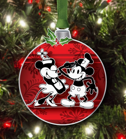 Circular Christmas ornament with two cartoon characters on a red background, hanging on a tree.