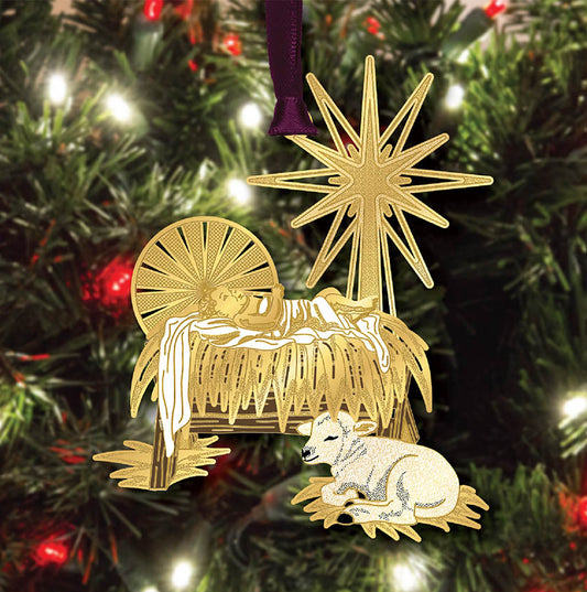 Gold nativity scene ornament on a Christmas tree with red and gold decorations.