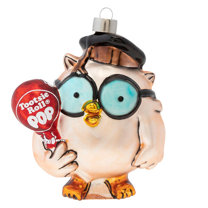Decorative owl ornament holding a Tootsie Pop candy on a white background
