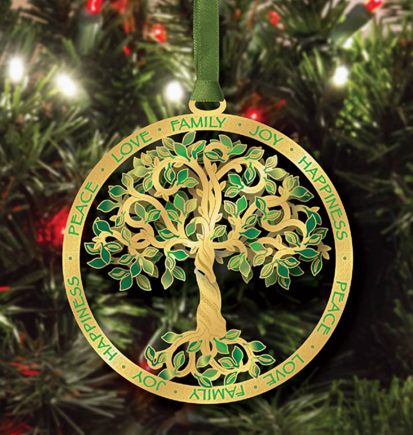 Decorative Christmas tree ornament with a tree design and inscribed words on a green ribbon against a Christmas tree background.
