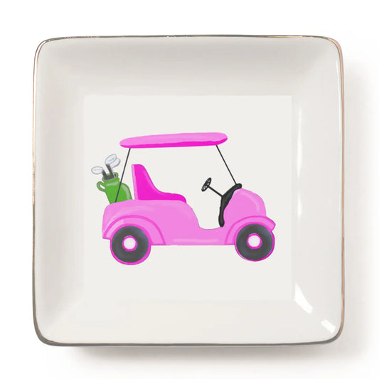 A square white ceramic plate with rounded corners and a thin metallic gold edge, featuring a colorful illustration of a pink golf cart with a green bag of golf clubs on a white background.