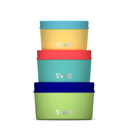 Set of four colorful 'S'well' brand containers stacked on a white background