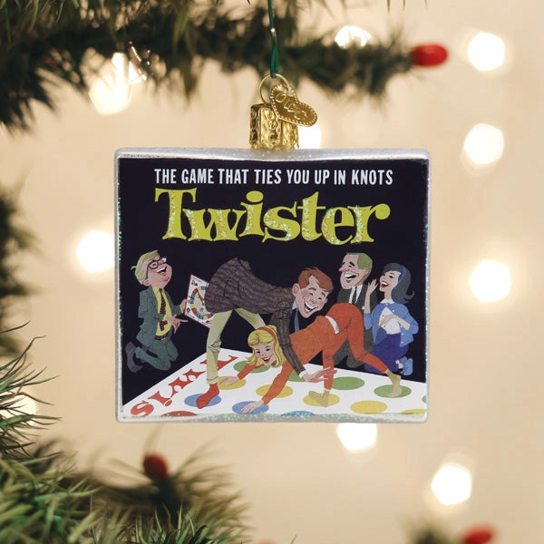 Twister game ornament hanging on a Christmas tree with blurred lights in the background