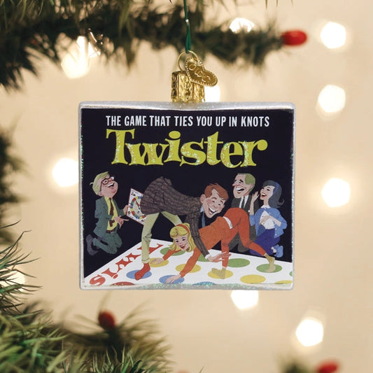 Twister game ornament hanging on a Christmas tree with blurred lights in the background